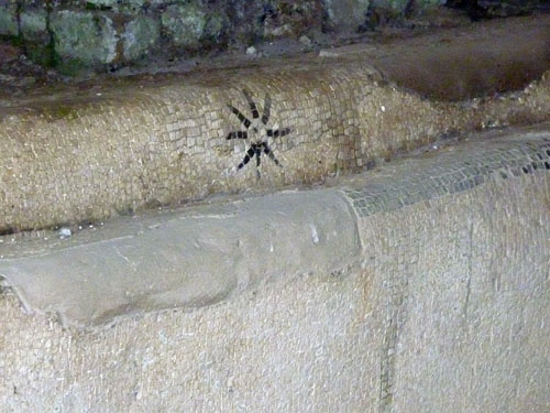 étoile sur une des banquettes du mithraeum des Sphères (Ostie)